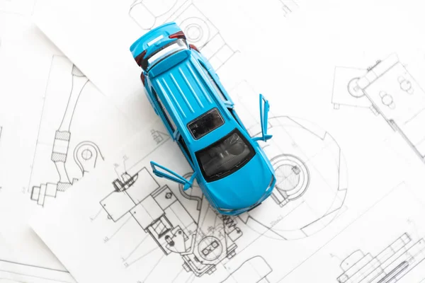 Mały model samochodu i arkusze planów — Zdjęcie stockowe