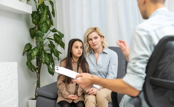 Küçük kız ve annesiyle birlikte çalışan çocuk psikoterapisti.