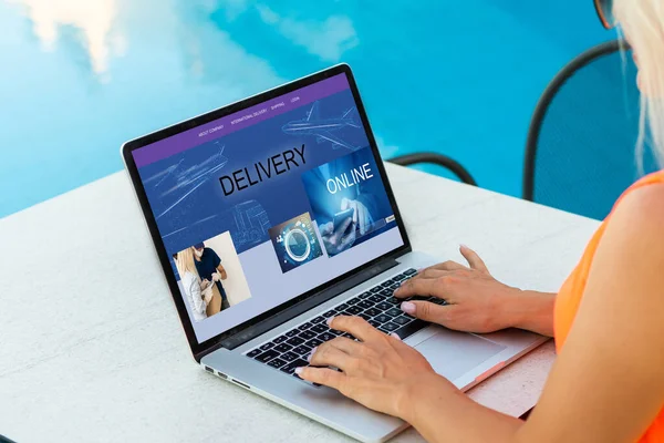 Female hands on laptop computer with parcel delivery application on screen at table in cafe — Stock Photo, Image