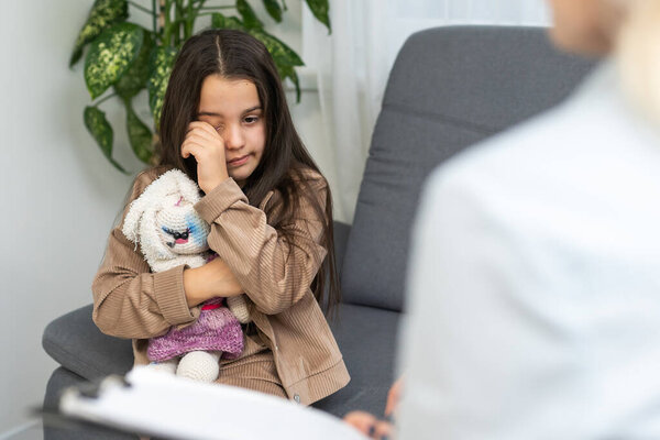 Детский психолог, работающий с маленькой девочкой
