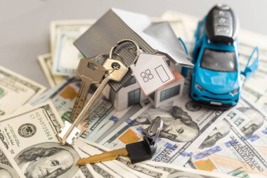 düz yatıyordu oyuncak araba, oyuncak ev, tuşları ile uzaktan kumanda alarm ve para masaya