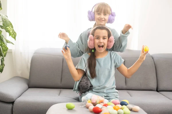 Due sorelline carine che giocano a caccia di uova a Pasqua. Adorabili bambini celebrano la Pasqua a casa. — Foto Stock