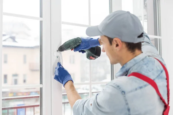 El trabajador instala y comprueba la ventana en la casa —  Fotos de Stock