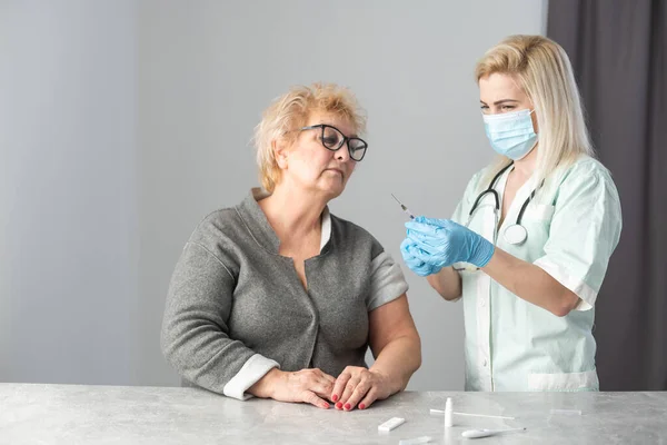 Медсестра крупным планом делает прививки пожилой женщине. — стоковое фото