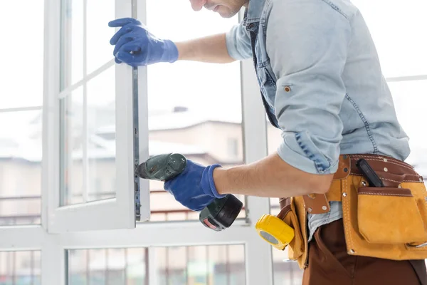 Trabajador de la construcción instalando ventana en casa. Handyman fijando la ventana con destornillador —  Fotos de Stock