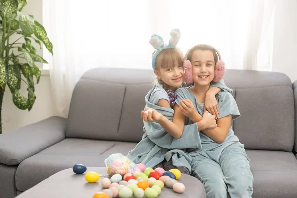 İki küçük kız paskalya yumurtasıyla oynuyor. Paskalya avı konsepti — Stok fotoğraf