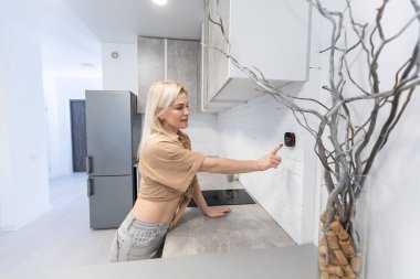 Evinde güzel mutlu kadın basma düğmesi dijital termostat