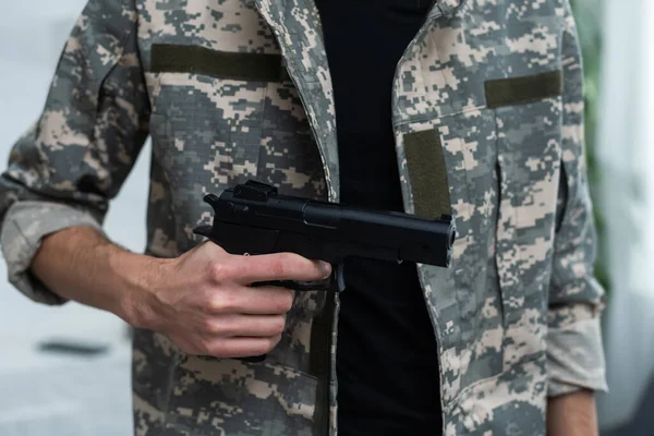 Pistol är en beväpnad man. Kamouflage. Vapen, beväpnad man, pistol, militär patrull. Mannen i kamouflage är beväpnad med pistol. — Stockfoto