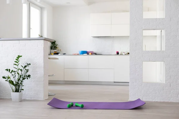 Träning hemma koncept, interiör, dekorativ sport i rummet med gym fitness motion lila matta, hantel — Stockfoto