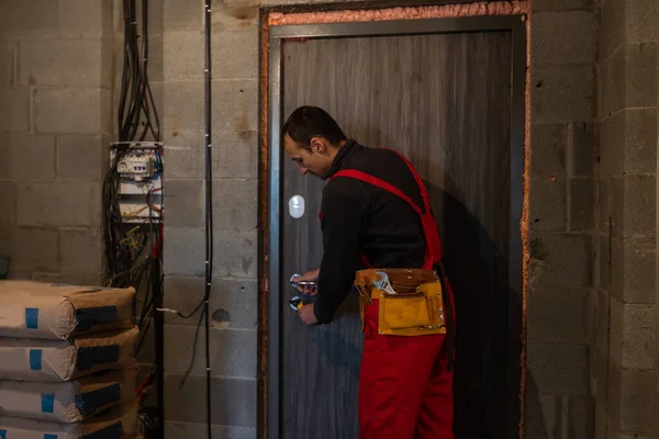 男性の便利屋大工インテリア木製のドアのロック インストールで — ストック写真