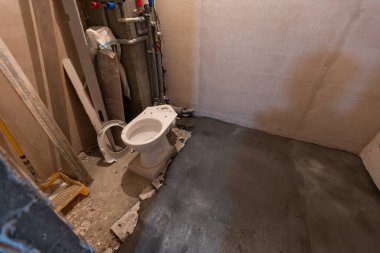 Tuvalet lavabosu banyoda. Tamir et. Hijyenik seramik. Tesisat işi. Su boruları. Plastik musluk. Yerde duran tuvalet..