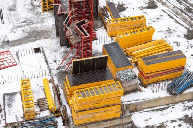 Vinçler ve işçiler temellere beton dökülüyor. İnşaat alanındaki inşaat çalışmalarına çimento dökülüyor. Kule vinçleri yeni bir yerleşim alanı inşa ediyor.