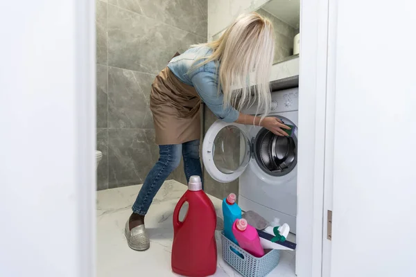 Женщина с оборудованием для уборки готова очистить дом на фоне ванной комнаты . — стоковое фото