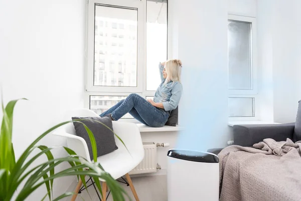 공기 청정제와 진정제를 사용하여 거실에 있는 여자 — 스톡 사진