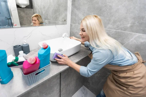 Kobieta z czyszczenia sprzęt gotowy do czyszczenia domu na tle łazienka. — Zdjęcie stockowe