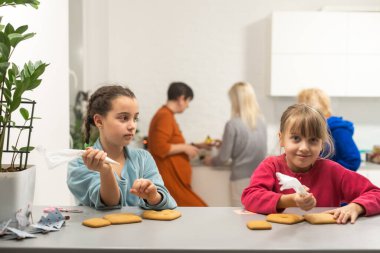 Evde zencefilli kurabiye yapan iki küçük kız..