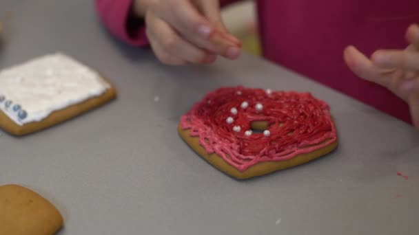 Girl decorates homemade gingerbread for Easter — Stock Video