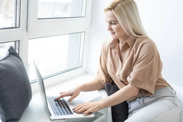 Miła piękna blondynka pracuje w notebooku usiąść na kanapie w domu - sprawdź na oline sklepy dla cyber sprzedaży poniedziałek - technologia kobieta koncepcja alternatywnego biura freelance — Zdjęcie stockowe