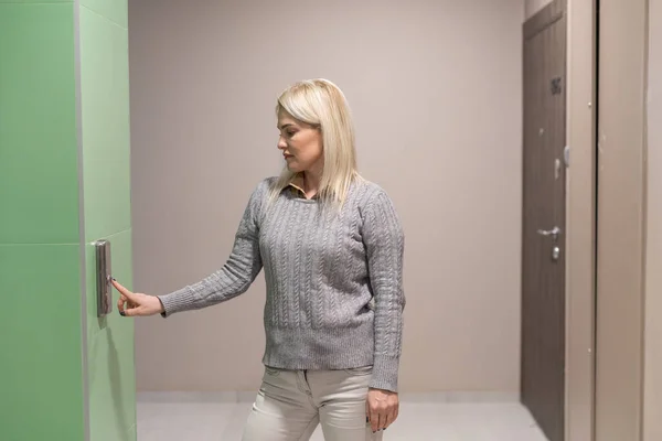 Mujer presiona el botón del ascensor. —  Fotos de Stock