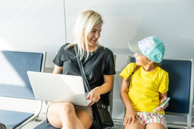 Laptop havaalanında çalışan anne kız.