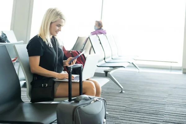 Mujer joven usando ordenador portátil en el aeropuerto — Foto de Stock