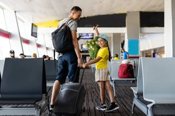 Взволнованная девочка с отцом в аэропорту после долгого ожидания — стоковое фото