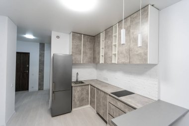 Gri mobilyalı, ahşap zeminli modern mutfak.