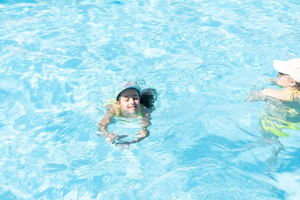 Família feliz. A mãe ensina a filha a nadar na piscina. Vista superior. — Fotografia de Stock