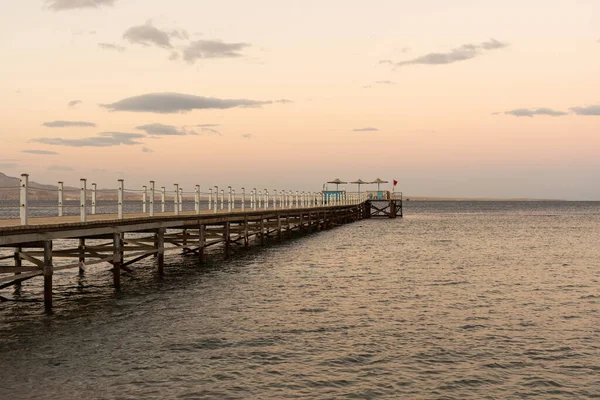 Gouden zee zonsondergang op de houten pier. — Stockfoto