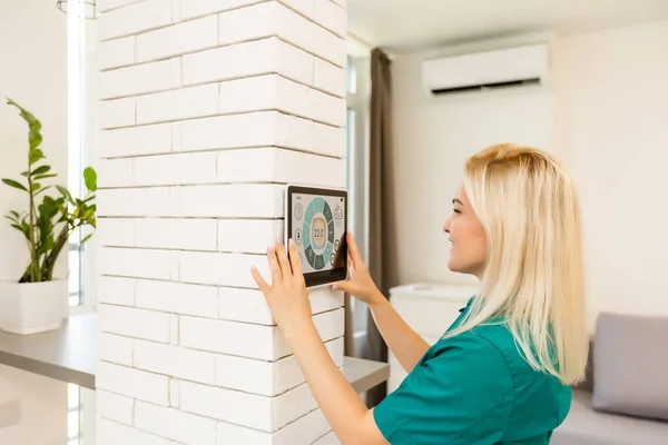 使用智能墙壁家庭控制系统的妇女 — 图库照片