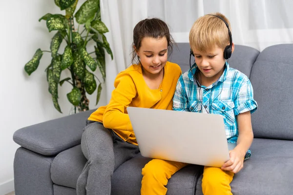 Bambini che giocano con il computer portatile a casa — Foto Stock