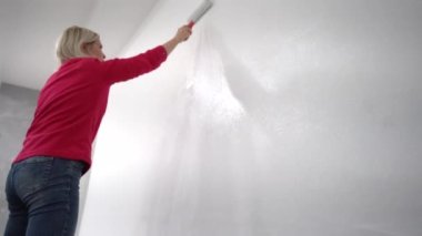 Kadın dekoratör boyama duvar kapalı rulo