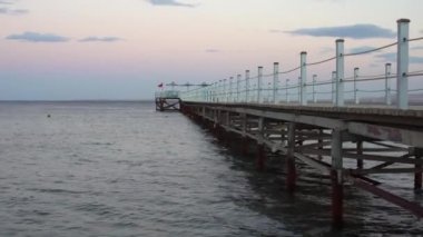 Tahta iskelede altın deniz gün batımı.