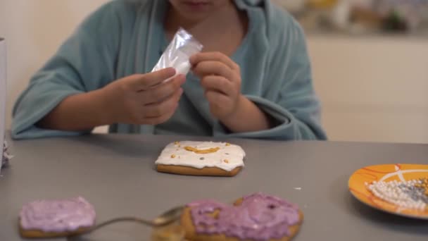 女の子はイースターのための自家製ジンジャーブレッドを飾る — ストック動画