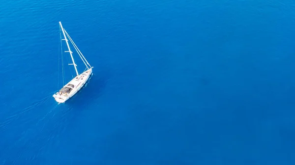 Вид с воздуха на пару, наслаждающуюся солнечными ваннами на роскошной яхте, движущейся в море. Отдых. — стоковое фото