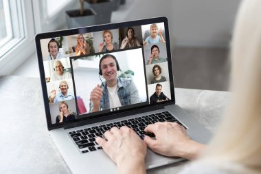 Video konferansında ya da telekonferansta doktor odasında dizüstü bilgisayarla vaka çalışmasını tartışan bir doktor. Webinar 'daki tıbbi ekip yakınlaştırma uygulaması, teletıp, tıbbi teknoloji kullanıyor..