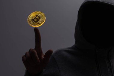 Bulanık iç mekandaki bilgisayar korsanlarının masasında parlayan bitcoin arayüzü olan bilgisayarlar kullanışının ön görüntüsü. Finans, hackleme, hırsızlık, teknoloji, kripto para ve döviz konsepti.