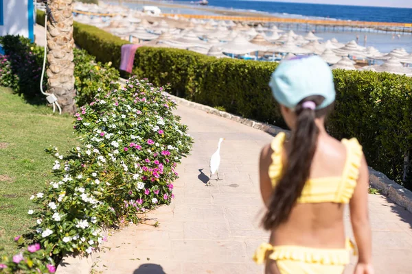 Foto eines kleinen Mädchens in Badeanzug und Hut am Strand — Stockfoto