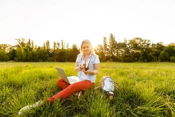 Mulher eufórica à procura de emprego com um laptop em um parque urbano no verão. — Fotografia de Stock