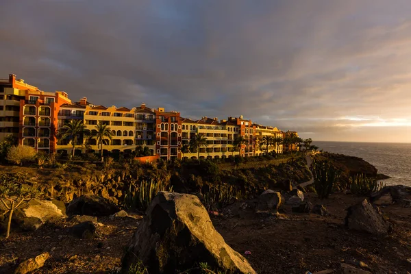 Panoramatický pohled Las Americas osvětlené v noci proti barevné západu slunce na obloze se světly na obzoru na ostrově Tenerife, Španělsko — Stock fotografie