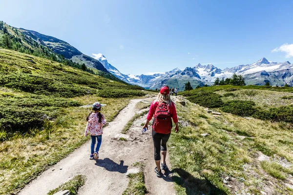 Пешие прогулки - туристка в походе с рюкзаком, живущая здоровым активным образом жизни. Пешая прогулка по горной природе в швейцарских Альпах, Швейцария. — стоковое фото