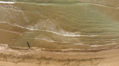 Doku dalgalarının üst görüntüsü kumlu sahil.