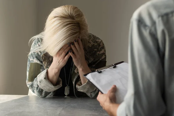 Hazafias katonanő. Fiatal, hazafias, pszichológussal beszélő katonai nő jegyzetel. — Stock Fotó