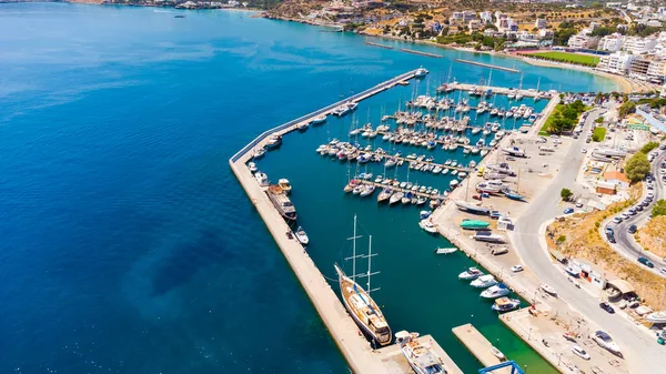 Město Agios Nicholas na ostrově Kréta v Řecku, v rámu je zátoka, turistická loď a ulice města — Stock fotografie