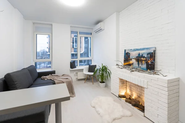Wohnzimmer-Interieur in grauen und braunen Farben verfügt über graues Sofa auf dunklen Hartholzböden mit Blick auf Steinkamin — Stockfoto