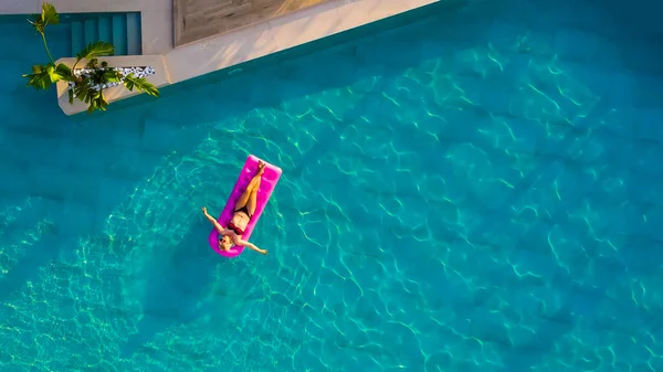 Donna galleggiante su materasso ad aria in piscina — Foto Stock