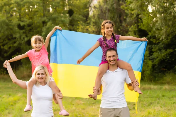 Ukrayna bayrağı taşıyan bir aile. Ukrayna 'nın Bağımsızlık Günü kutlu olsun. Ulusal Bayrak Günü. Memleketi ve sembolleri sevmek. Boşluğu kopyala. — Stok fotoğraf