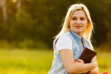 Tanrı 'nın gücü ve gücü için dua eden genç bir kadın altın bir çayırda güneşin doğuşunda. Tanrı ve maneviyat kavramı.