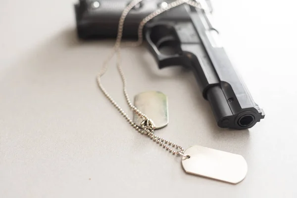 Gun and dogtag isolated on a white background. — Stock Photo, Image