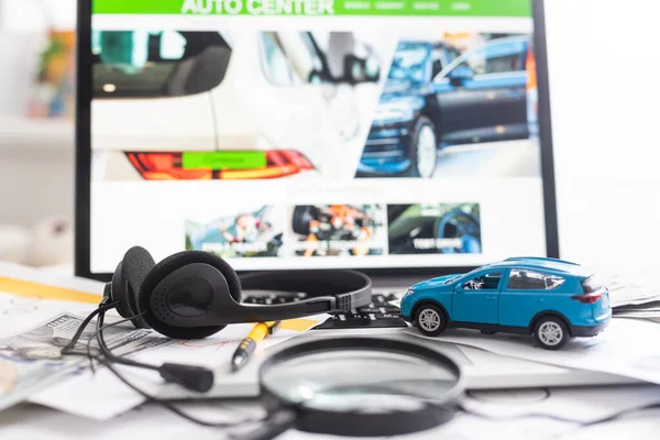 노트북 위에 달러가 있는 장난감 자동차가 있습니다. 프로그래머 — 스톡 사진